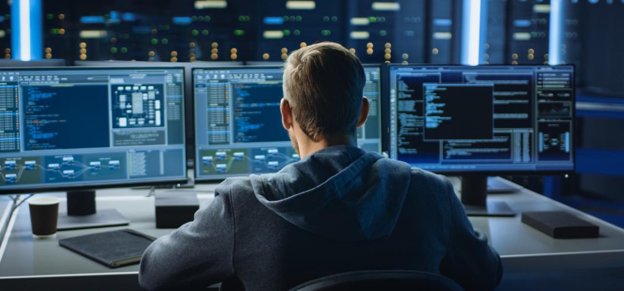 CRI man sitting at multiscreen computer workstation